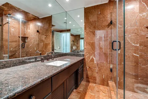 a bathroom with a granite countertop sink a shower and a mirror