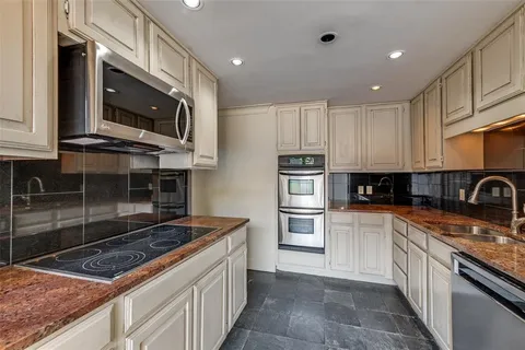 a kitchen with stainless steel appliances granite countertop a stove top oven microwave and cabinets