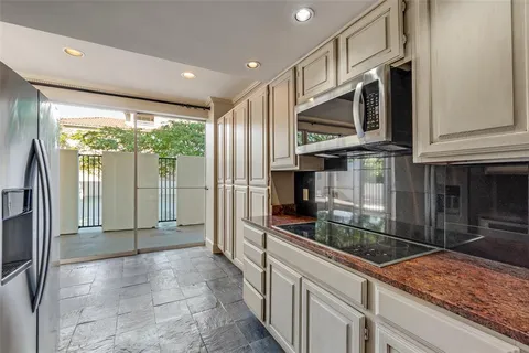a kitchen with stainless steel appliances granite countertop a refrigerator and a sink