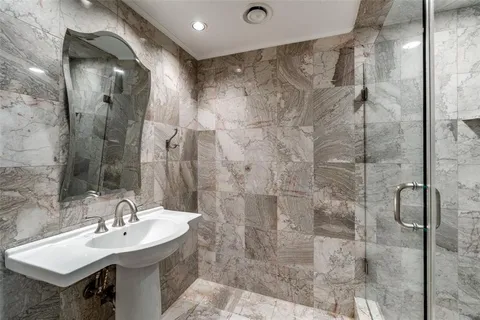 a bathroom with a sink shower and a mirror