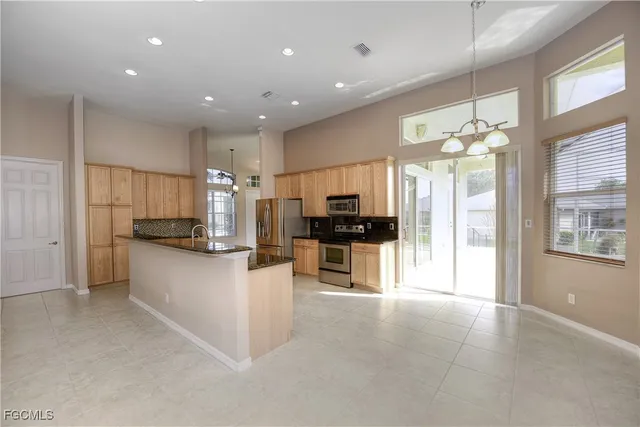 a kitchen with kitchen island granite countertop lots of counter top space and stainless steel appliances