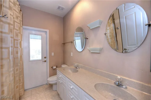 a bathroom with a granite countertop toilet a sink and a mirror