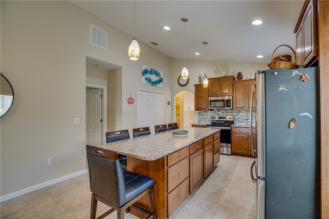 2965 Louetta Circle Melbourne, FL 32901 - Photo 12 of 36 a kitchen with granite countertop a refrigerator a sink and a stove top oven