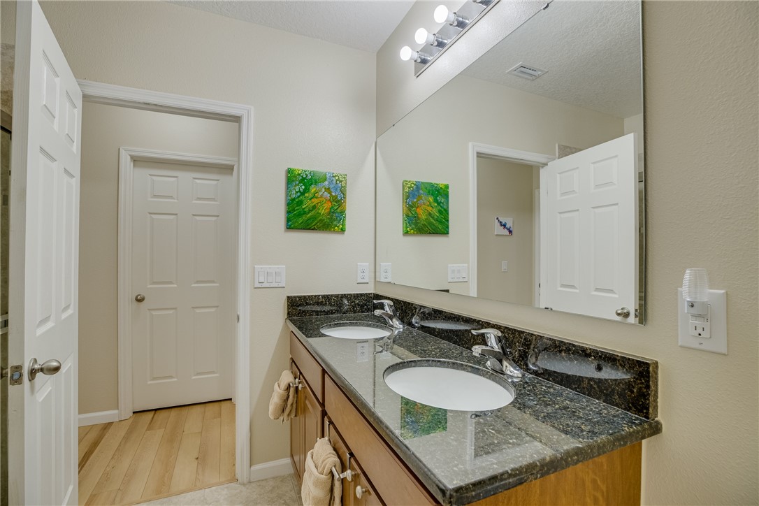 2965 Louetta Circle Melbourne, FL 32901 - Photo 23 of 36 a bathroom with a granite countertop sink and a mirror