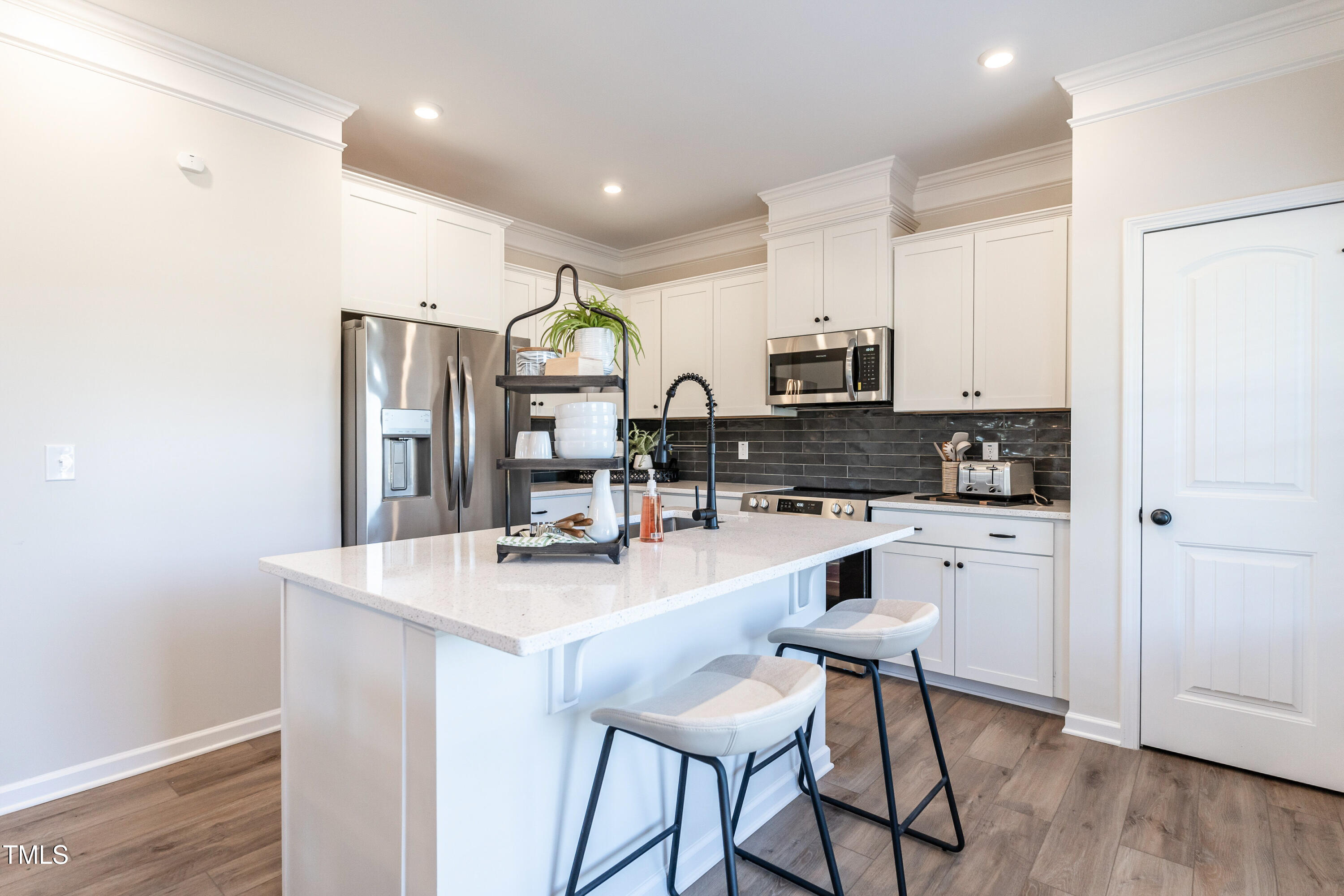 306 Deodora Lane Cameron, NC 28326 - Photo 10 of 27 a kitchen with stainless steel appliances granite countertop a stove a sink a refrigerator a microwave oven with white cabinets and wooden floor