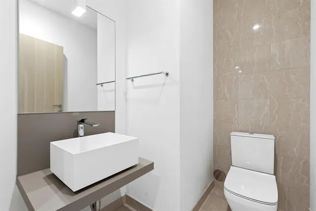 a white toilet sitting next to a bathroom sink