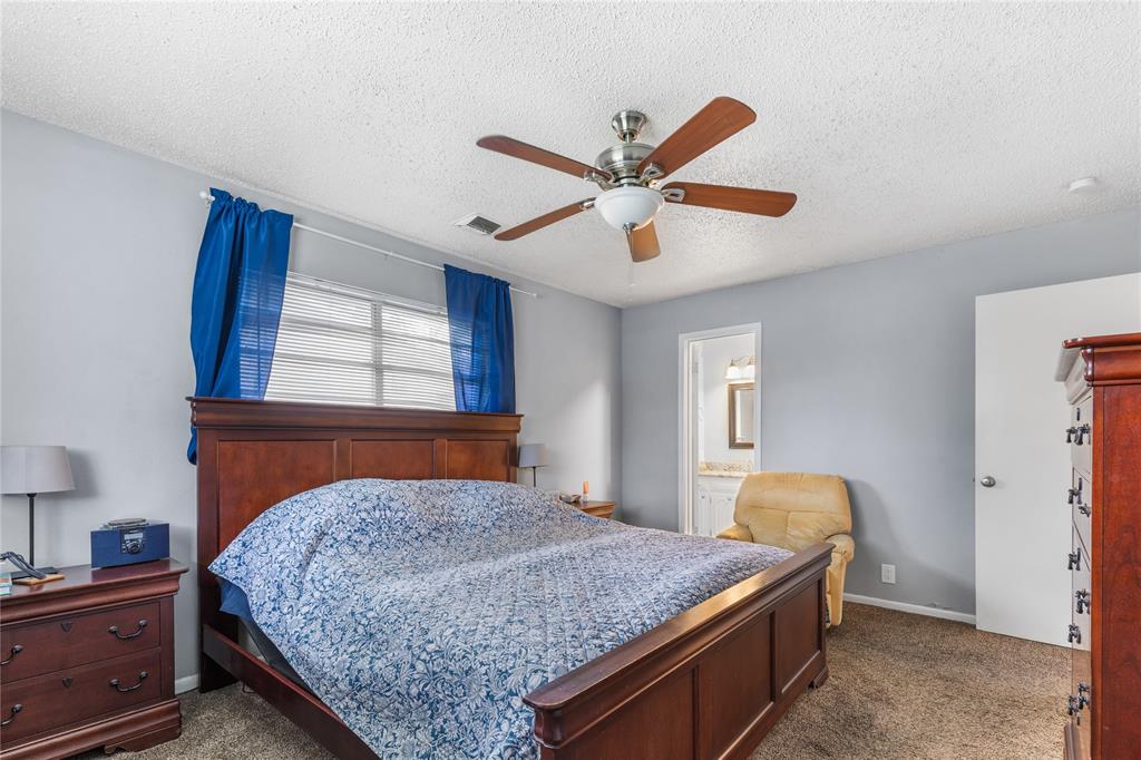 613 Edwards Drive Denison, TX 75020 - Photo 16 of 31 a bedroom with a bed and a chandelier