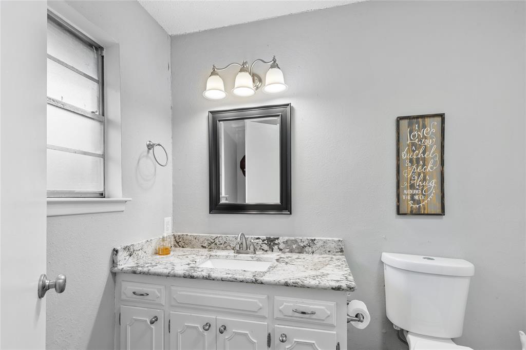 613 Edwards Drive Denison, TX 75020 - Photo 20 of 31 a bathroom with a toilet sink and mirror