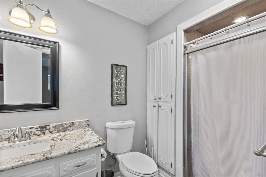 613 Edwards Drive Denison, TX 75020 - Photo 21 of 31 a bathroom with a granite countertop sink toilet and shower