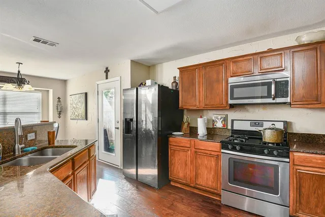 a kitchen with stainless steel appliances granite countertop a refrigerator stove and sink