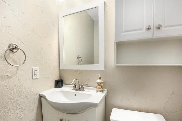 a bathroom with a sink mirror and toilet
