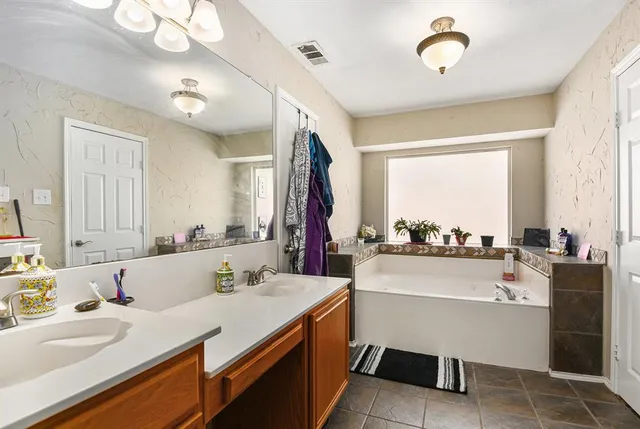 a room with a sink bed and large windows