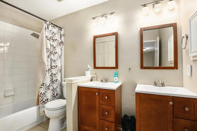 a bathroom with a double vanity sink mirror and toilet
