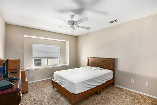 a bedroom with a bed and a ceiling fan