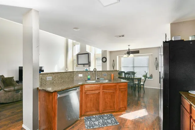 a kitchen with stainless steel appliances granite countertop a sink and a refrigerator