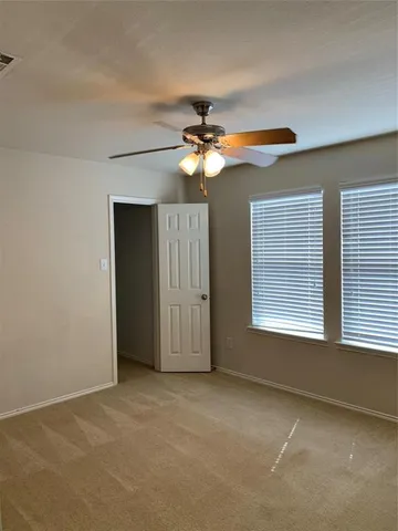 a view of a livingroom with a ceiling fan and window