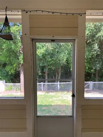 a view of a yard with wooden fence and trees