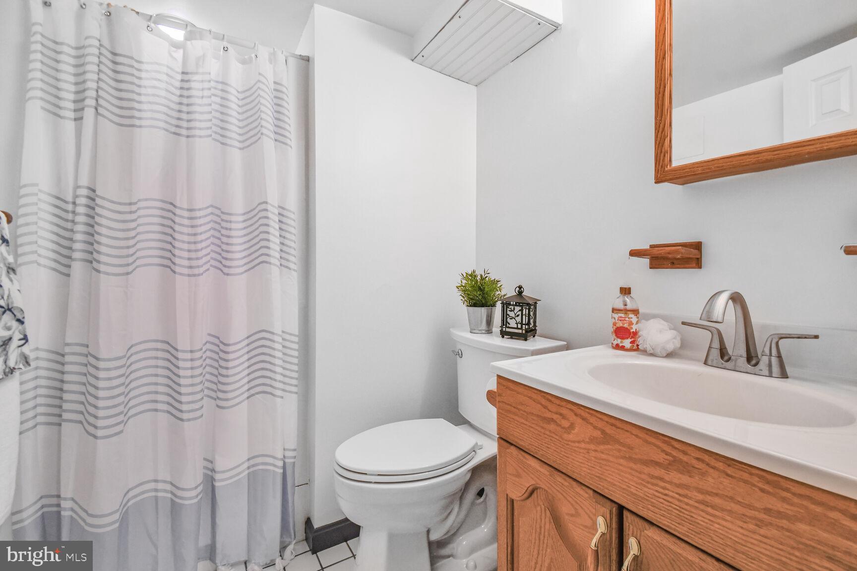 1002 Laredo Road Silver Spring, MD 20901 - Photo 13 of 70 a bathroom with a sink a toilet and shower curtain