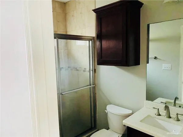 a bathroom with a granite countertop toilet and a sink