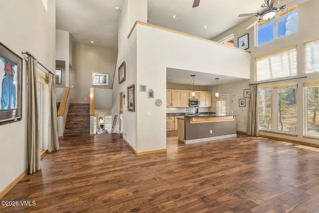 a view of a kitchen with refrigerator and wooden floor