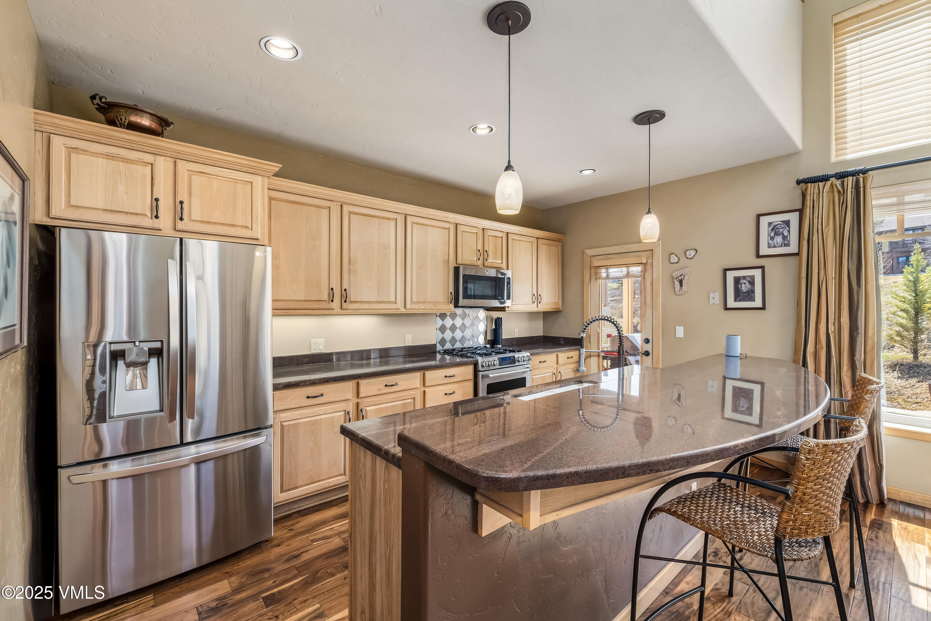 111 East Double Hitch Eagle, CO 81631 - Photo 7 of 38 a kitchen with stainless steel appliances granite countertop a refrigerator a stove a sink a dining table and chairs with wooden floor