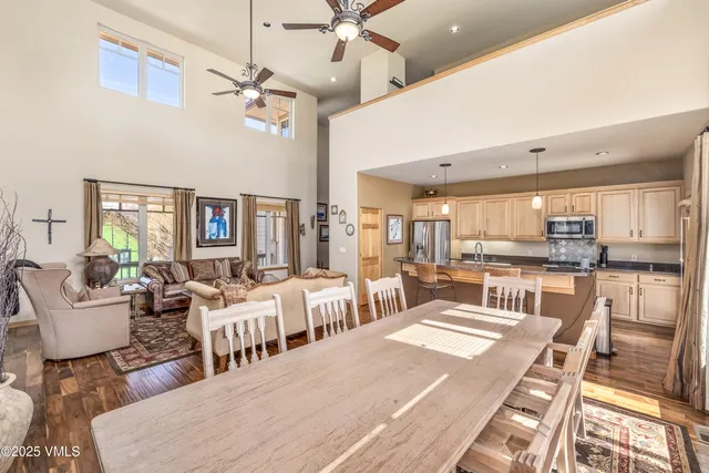a living room with lots of white furniture and a table