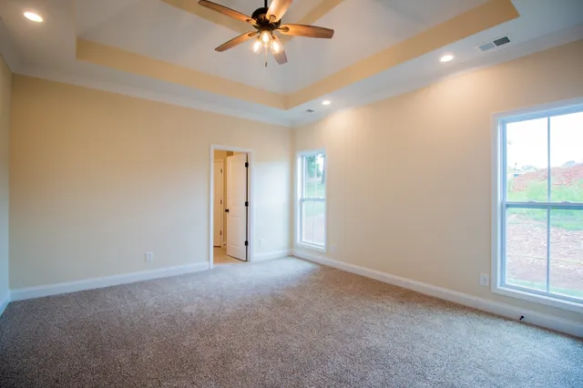 a view of an empty room with a chandelier fan