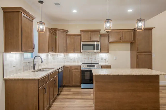 a kitchen with kitchen island a sink stainless steel appliances and cabinets