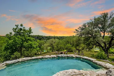 a view of a swimming pool with a yard and sitting area