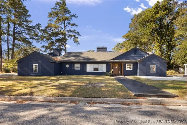 a view of a house with a yard and large tree