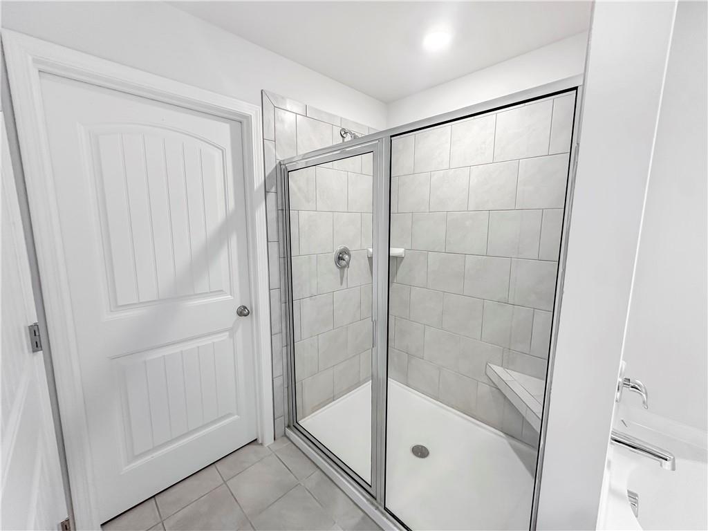 965 Athena Bend Fairburn, GA 30213 - Photo 13 of 37 a bathroom with a glass shower door