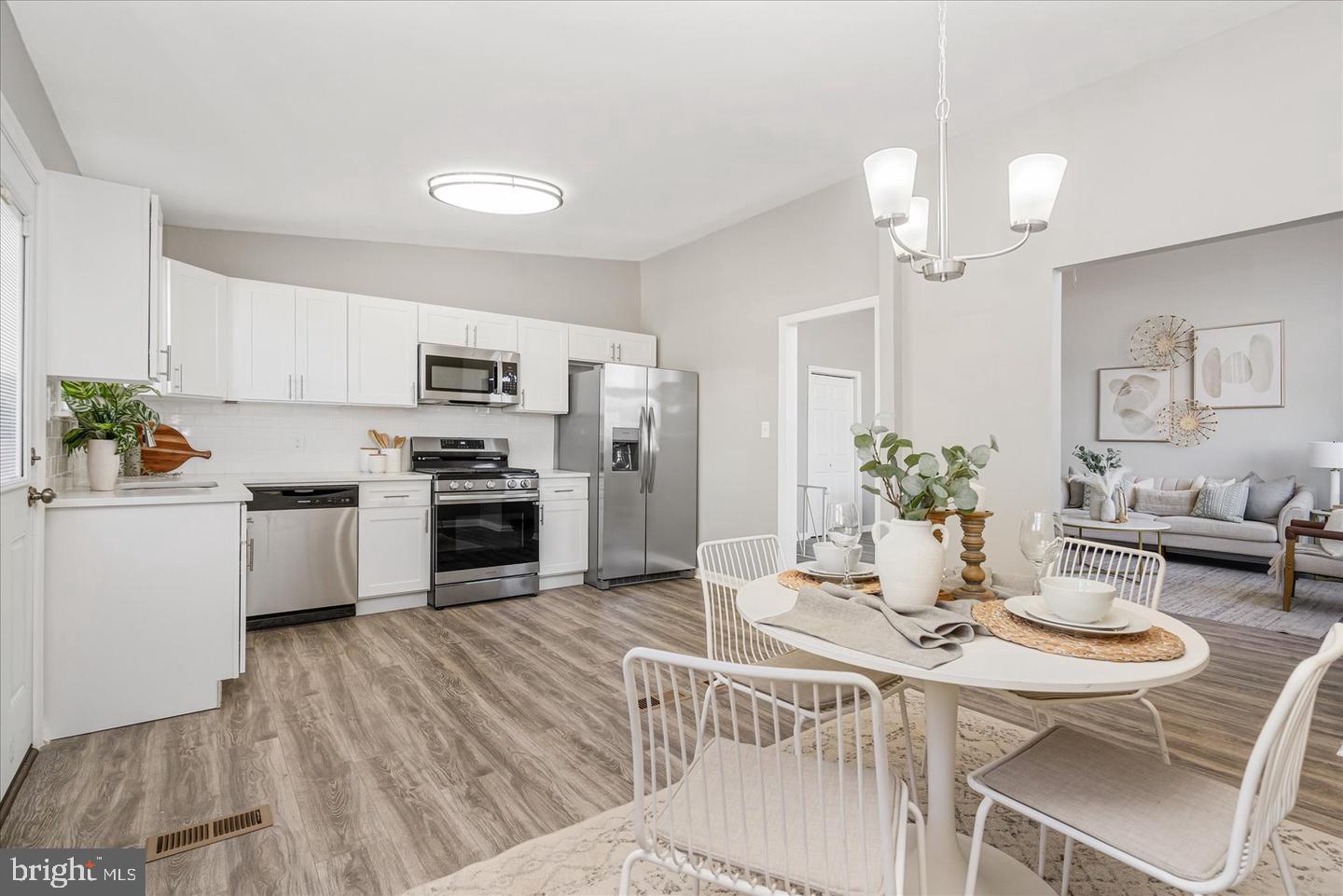 4609 Tema Road Pikesville, MD 21208 - Photo 9 of 36 a kitchen with white cabinets stainless steel appliances and dining table