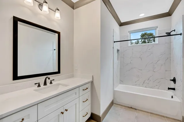a bathroom with a tub a sink and mirror
