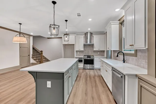 a kitchen with stainless steel appliances a sink stove and refrigerator