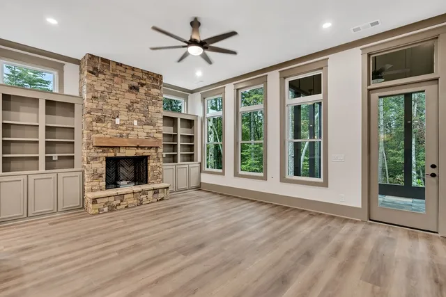a view of an empty room with a fireplace and a window