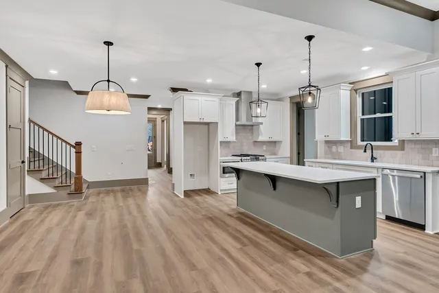 a kitchen with kitchen island granite countertop a sink appliances and cabinets