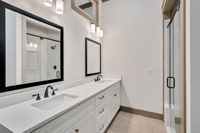 a bathroom with double vanity sink and a mirror