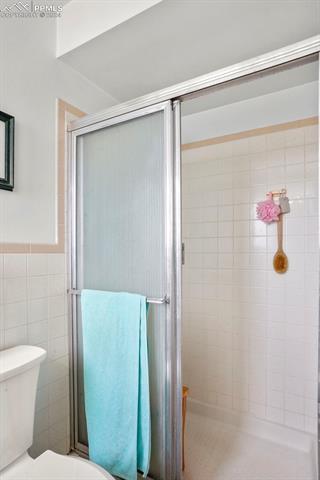 8155 Soap Weed Road Calhan, CO 80808 - Photo 19 of 39 Bathroom featuring toilet and tile walls