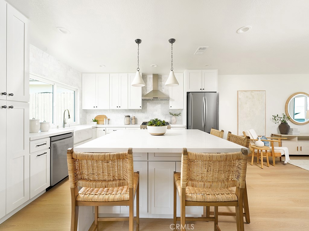 33271 Ocean Hill Drive Dana Point, CA 92629 - Photo 16 of 43 a kitchen with stainless steel appliances kitchen island granite countertop a table chairs and a refrigerator