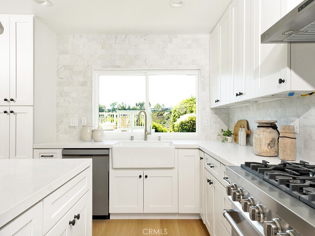 33271 Ocean Hill Drive Dana Point, CA 92629 - Photo 18 of 43 a kitchen with granite countertop white cabinets and a stove top oven