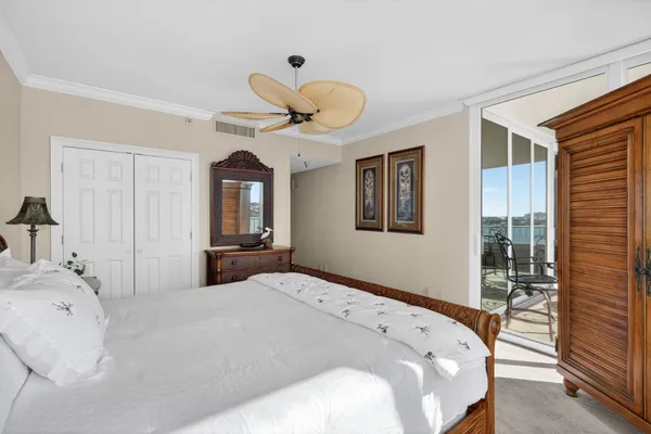 a bedroom with a bed and a flat tv screen on the dresser