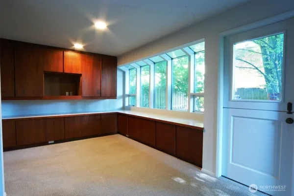 a kitchen with large window and wooden floor