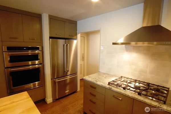 a kitchen with wooden cabinets and stainless steel appliances