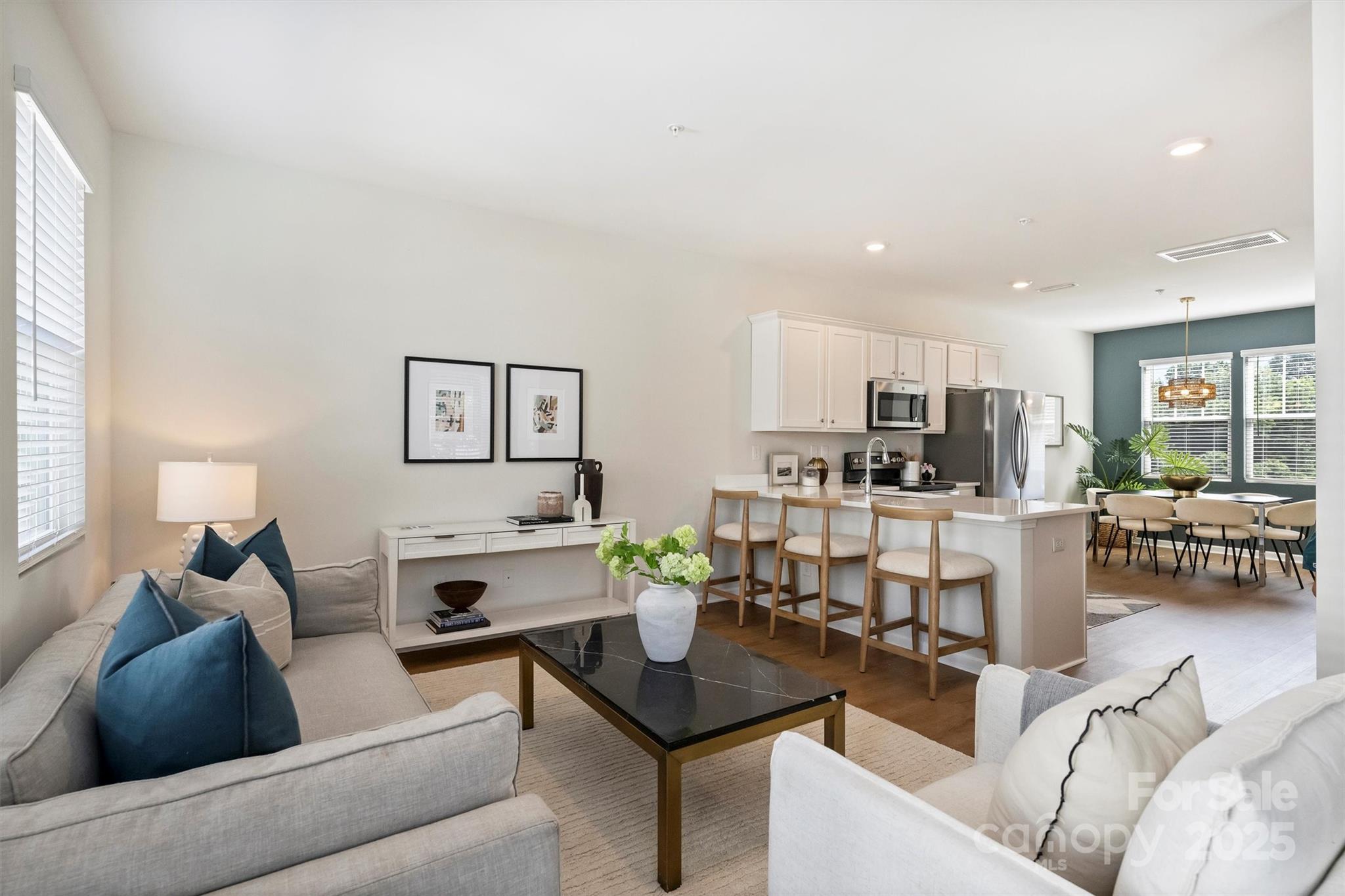 a living room with furniture and view of kitchen