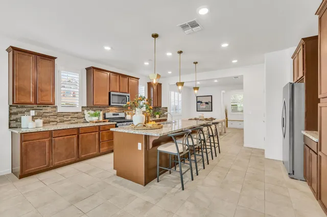 a kitchen with stainless steel appliances granite countertop a stove oven and a refrigerator