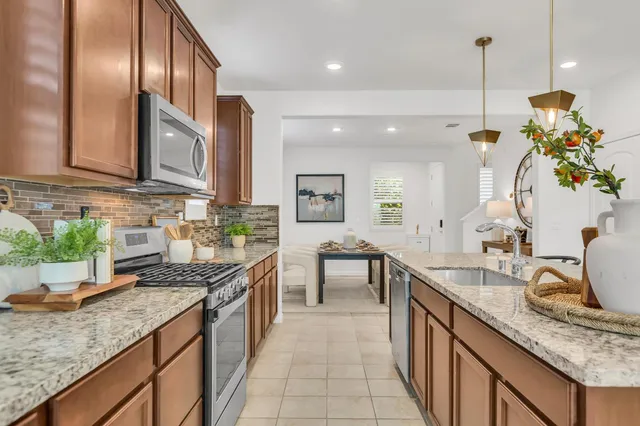 a kitchen with stainless steel appliances granite countertop a stove and a microwave