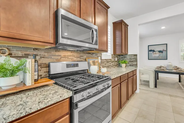a kitchen with stainless steel appliances granite countertop a refrigerator and a sink