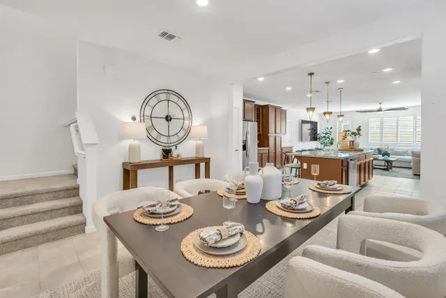 a dining room with furniture a kitchen and chandelier