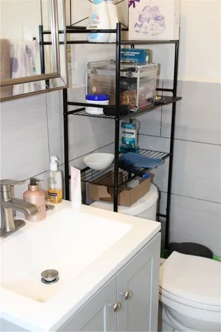 a bathroom with a sink a toilet and a mirror