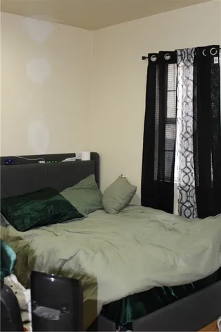 a large bed sitting in a bedroom next to a window